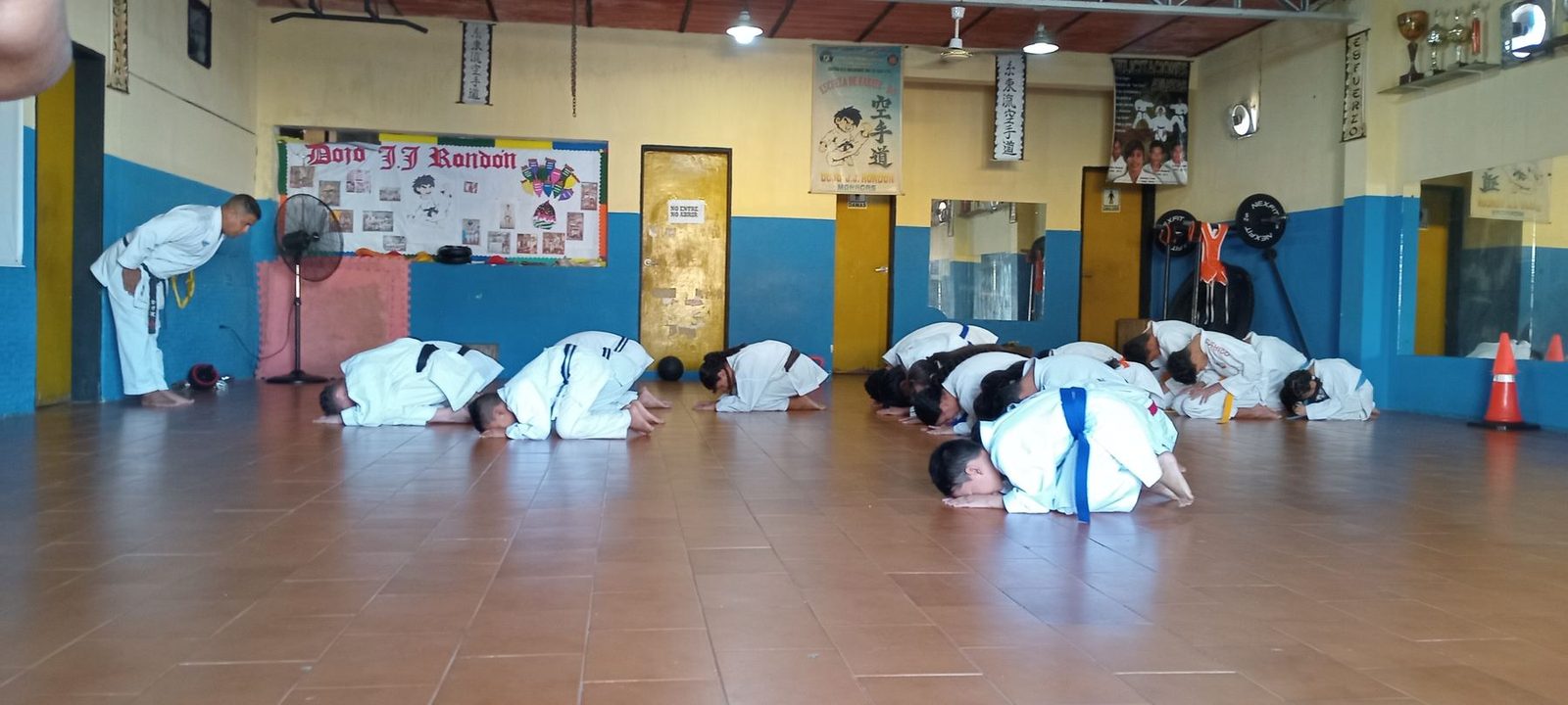 Los alumnos del dojo, arrodillados en el tatami, hacen la reverencia con la que empieza y termina cada clase